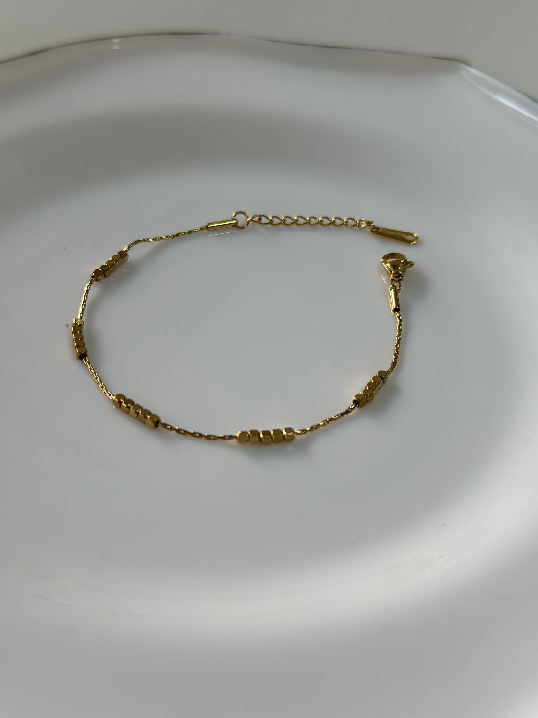 Gold bracelet on a white plate