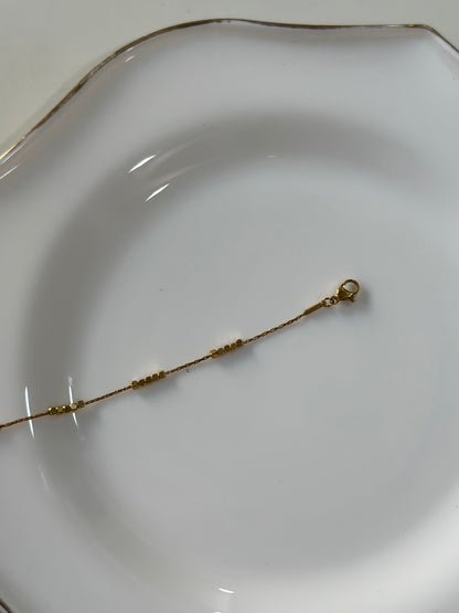 Gold bracelet on a white plate