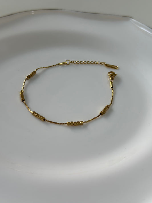 Gold bracelet on a white plate