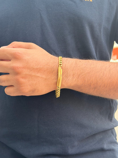 Gold bracelet on a person's wrist against a dark blue shirt